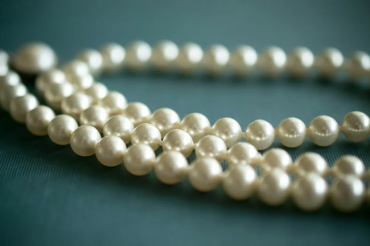 Strand of white pearls on slate-blue cloth