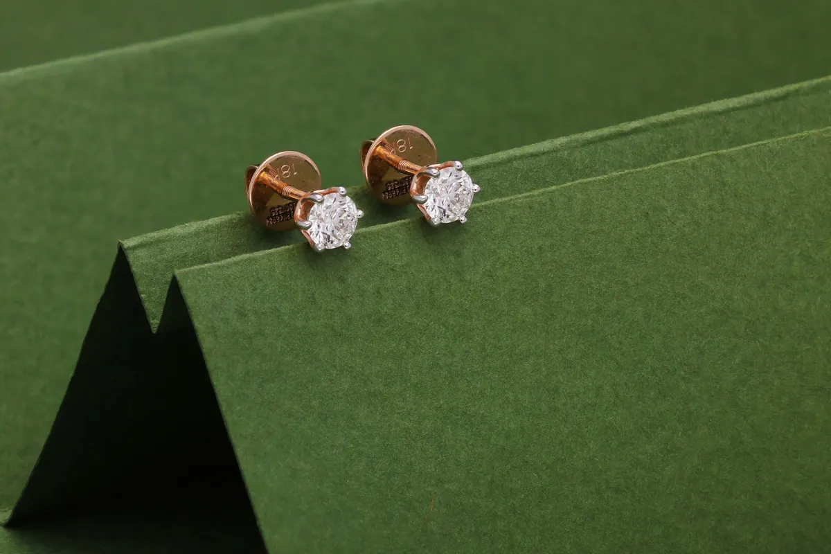 Pair of diamond solitaire studs on a green card