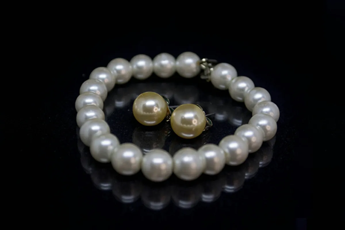Pearl bracelet with golden pearl studs on black glass